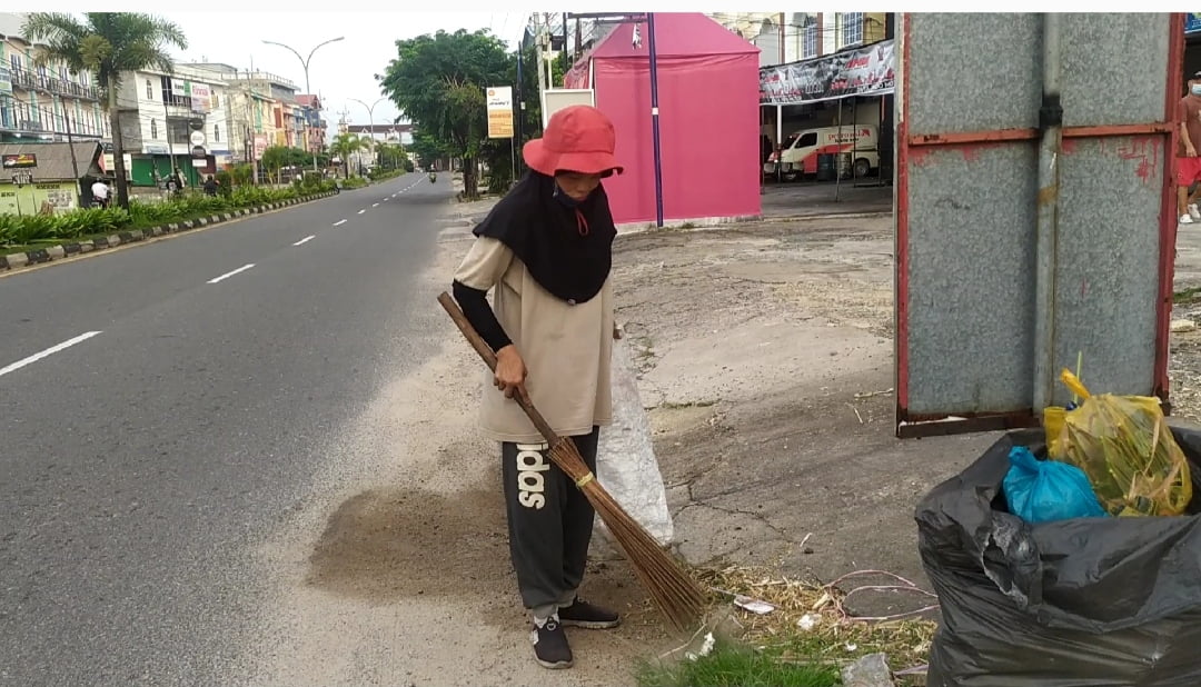Petugas penyapu jalan, Endang, Sedang menjalankan tugasnya di Jalan D.I Panjaitan Kota Tanjung Pinang.