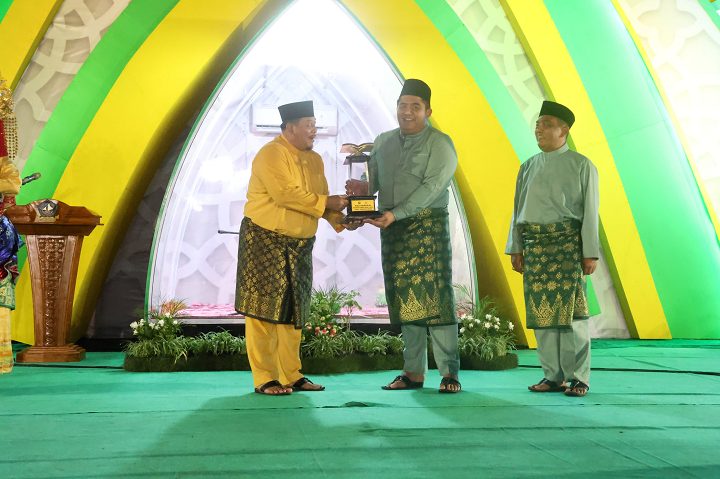 Camat Toapaya, Ivan Golar Riadi menyerahkan piala bergilir MTQH Kabupaten Bintan ke Bupati Bintan, Roby Kurniawan.
