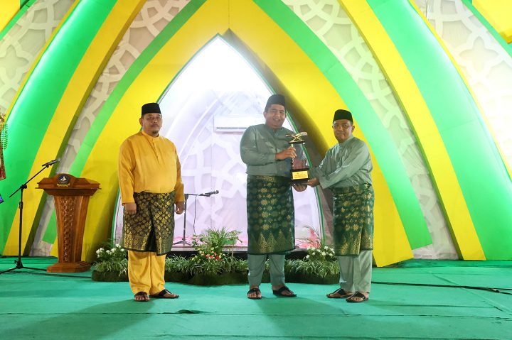 Bupati Bintan, Roby Kurniawan menyerahkan piala MTQH ke-XIII Kabupaten Bintan bergilir kepada Asisten Pemerintahan dan Kesra Sekretariat Daerah Kabupaten Bintan, Wan Rudi Iskandar.